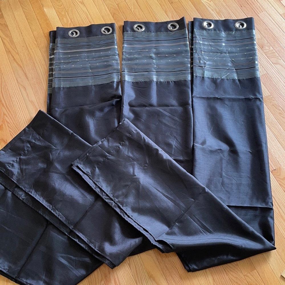 3 black and gray curtain panels with silver grommets.